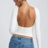 Bluză albă cu guler înalt, mâneci lungi și spate decupat, din modal, model Elli Bluză albă cu guler înalt, mâneci lungi și spate decupat, din modal, model Elli