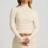 Bluză Auri din modal, cu guler înalt, fără spate și drapată, în culoarea ivoriu Bluză Auri din modal, cu guler înalt, fără spate și drapată, în culoarea ivoriu