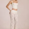 Pantaloni evazați din dantelă transparentă, cu talie medie, model Calista, culoare ivoriu Pantaloni evazați din dantelă transparentă, cu talie medie, model Calista, culoare ivoriu