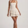 Rochie mini asimetrică cu gât halter și straturi, model Rosaria, în culoarea ivoriu