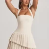 Rochie mini asimetrică cu gât halter și straturi, model Rosaria, în culoarea ivoriu