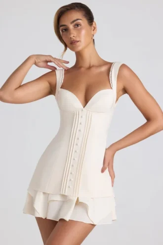 Rochie mini corset Cassandra cu volane și detalii cu nasturi, culoare ivoriu Rochie mini corset Cassandra cu volane și detalii cu nasturi, culoare ivoriu