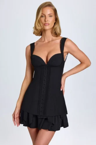 Rochie mini corset Cassandra cu volane și detalii cu nasturi, în negru Rochie mini corset Cassandra cu volane și detalii cu nasturi, în negru