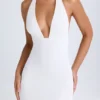 Rochie mini Vella cu guler înalt și spate decupat, de culoare albă Rochie mini Vella cu guler înalt și spate decupat, de culoare albă