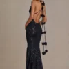 Rochie neagră cu decolteu adânc și spate decupat, cu ornamente Etoile Rochie neagră cu decolteu adânc și spate decupat, cu ornamente Etoile